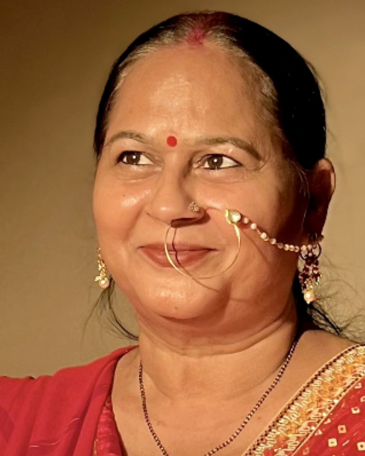 Rekha Shukla, the woman behind House of Radha, smiling in a red saree